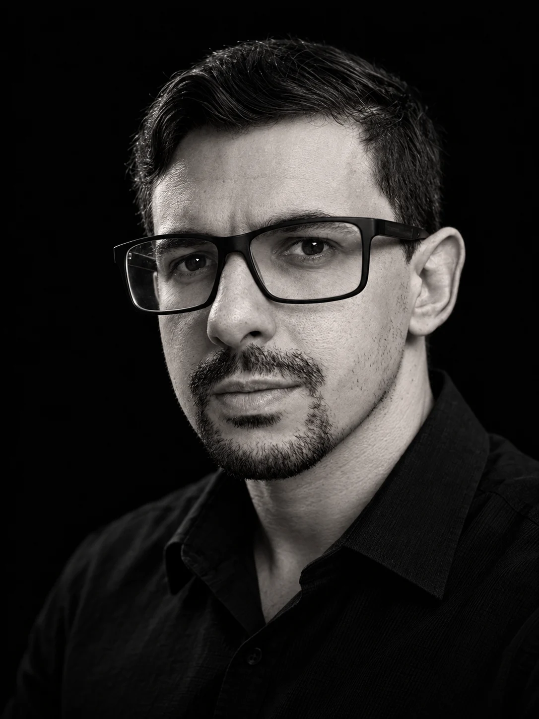 Black and white portrait of Daniel Paz wearing glasses